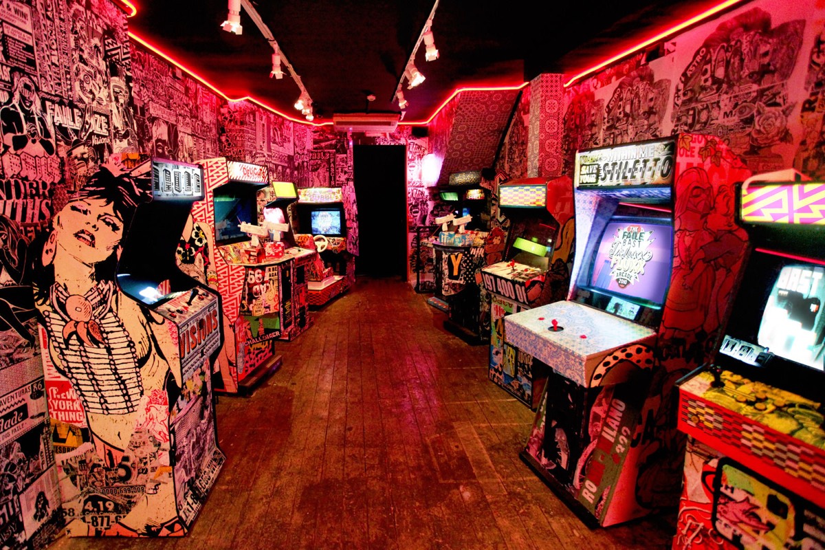 FAILE’s neon-lit arcade installation, lined with hand-painted cabinets and walls.