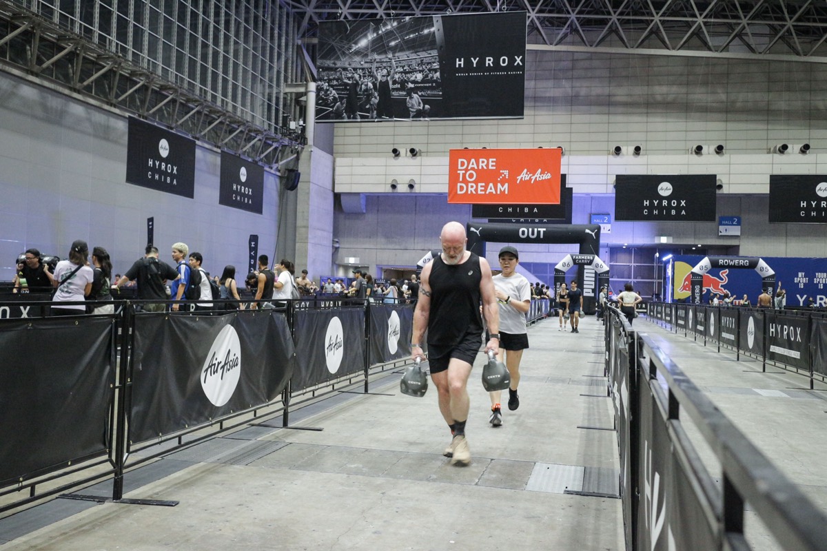 Eric carrying kettlebells during a Hyrox competition in Chiba.